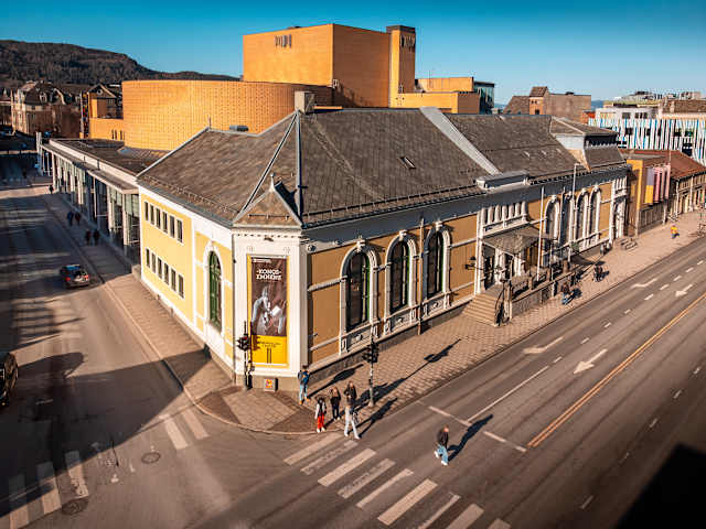 Foto av bygget til Trøndelag Teater som er et gult byhus med store vinduer.