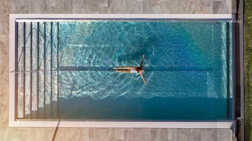 Kvinna som simmar i pool 