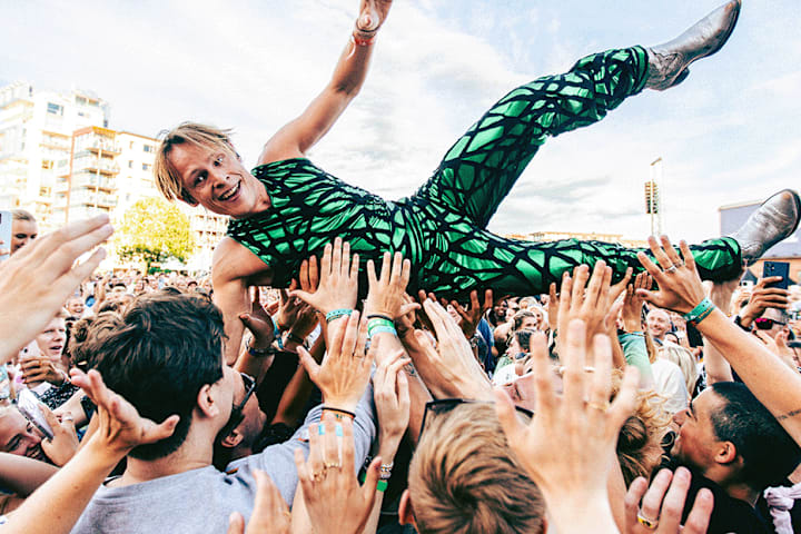 Foto av artisten Sondre Justad som crowd-surfer på en konsert.