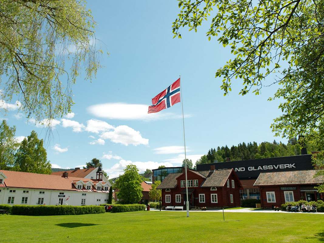 Et par beskuer lampene hos Hadeland Glassverk. De smiler. De har også jakkene på.