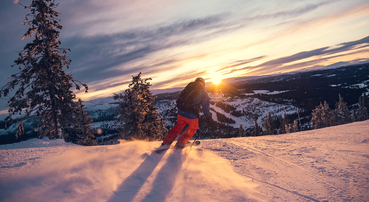 En person på slalåm i solnedgangen