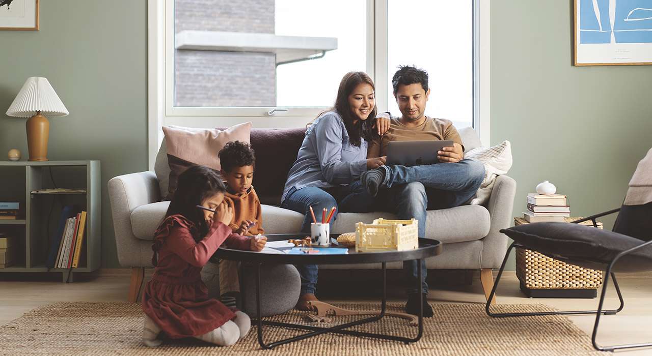 En familie med to barn og foreldre i en sofa