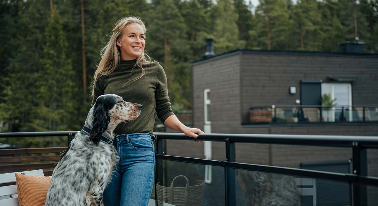 Kvinne med hund på terrasse i OBOS Block Watne-bolig