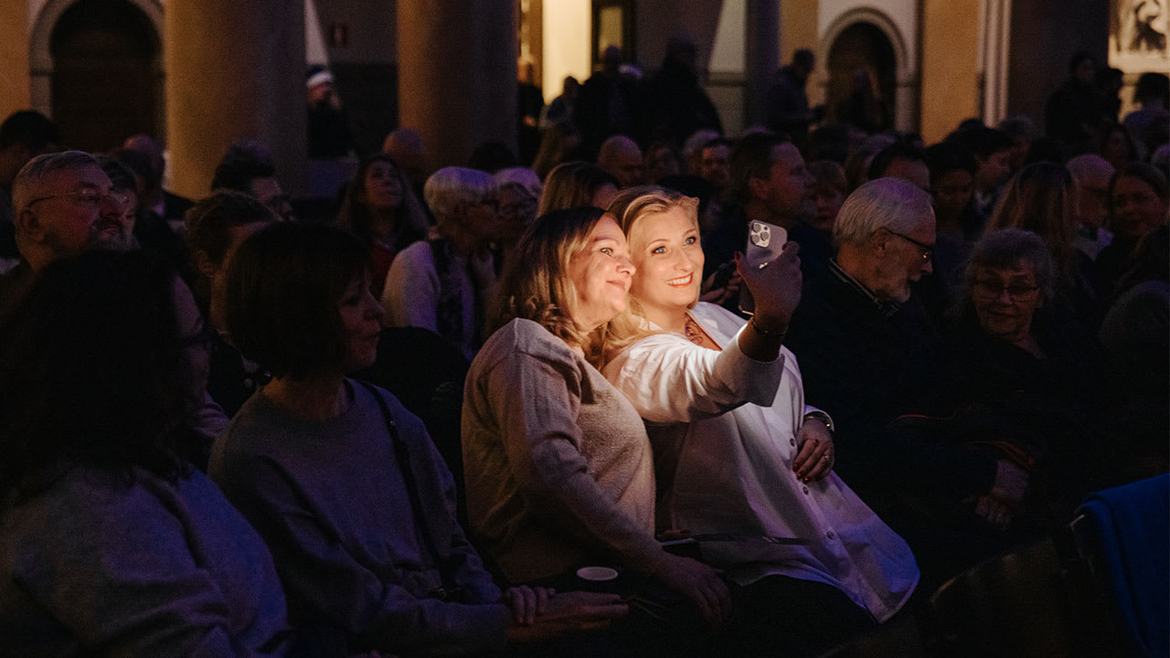 Två kvinnor som tar selfie i publiken