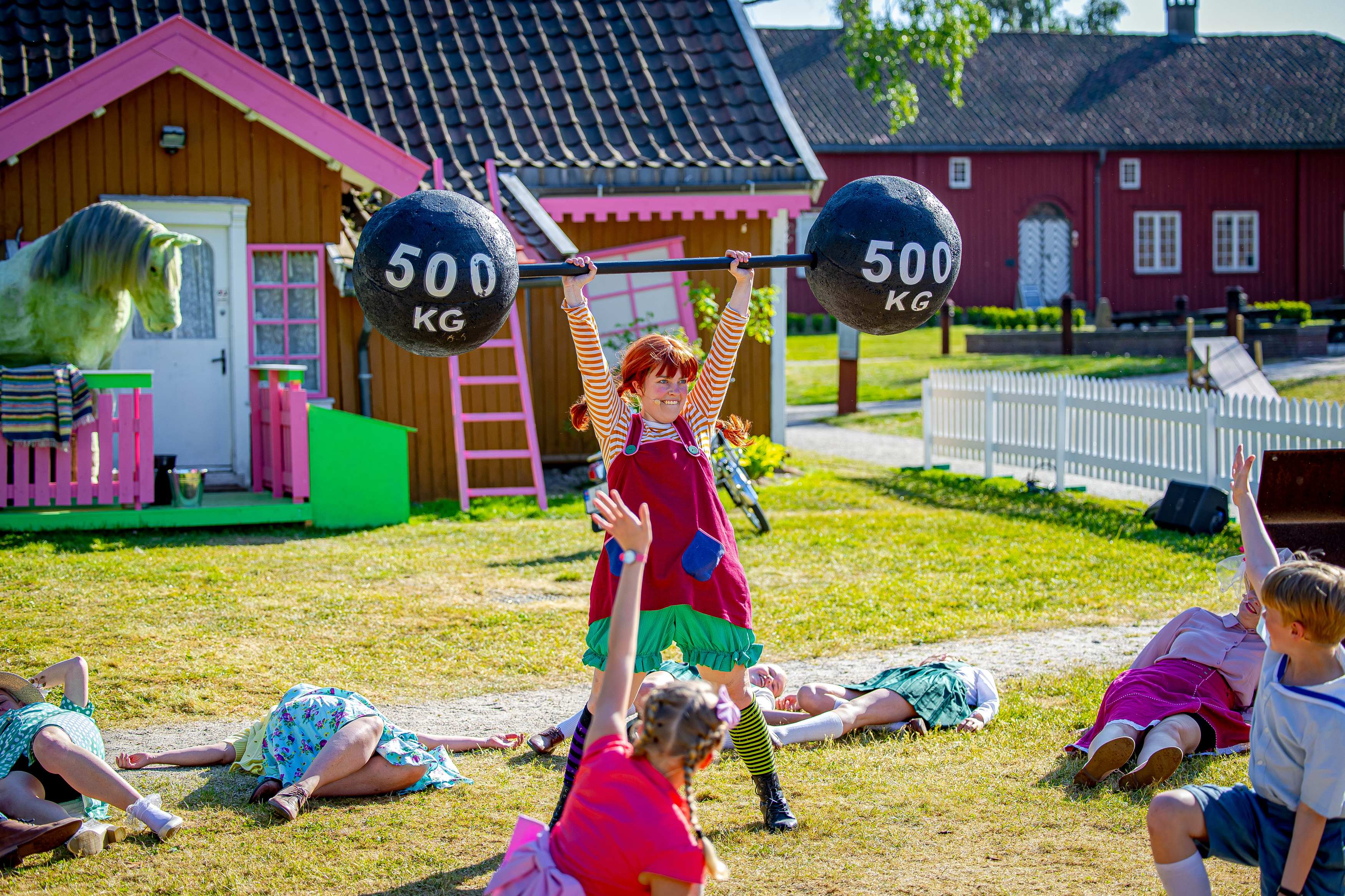 Foto av en utendørs teaterscene med Pippi Langstrømpe som verdens sterkeste jente.