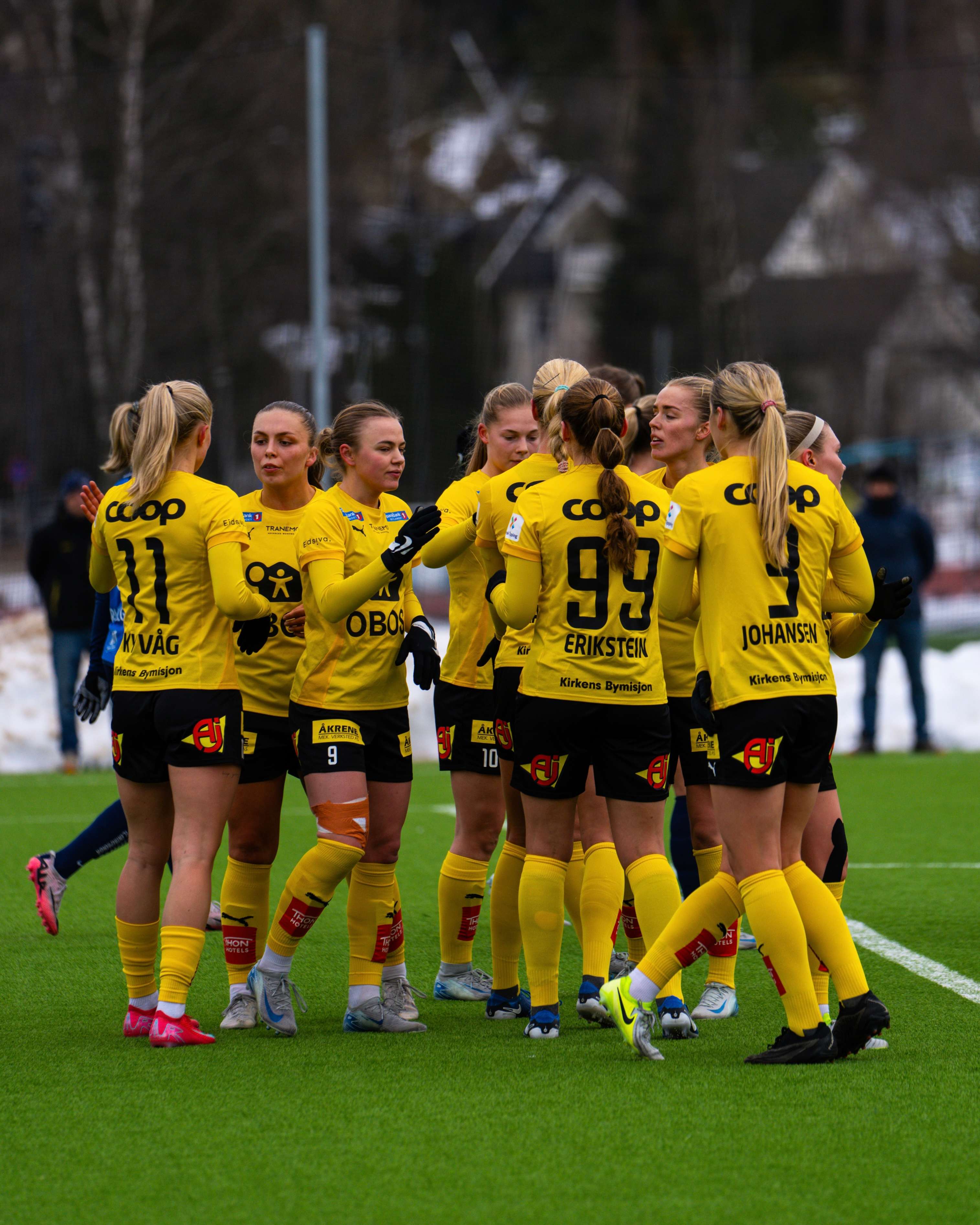 Foto av fotballaget Lillestrøm Kvinner som samles på fotballbanen.