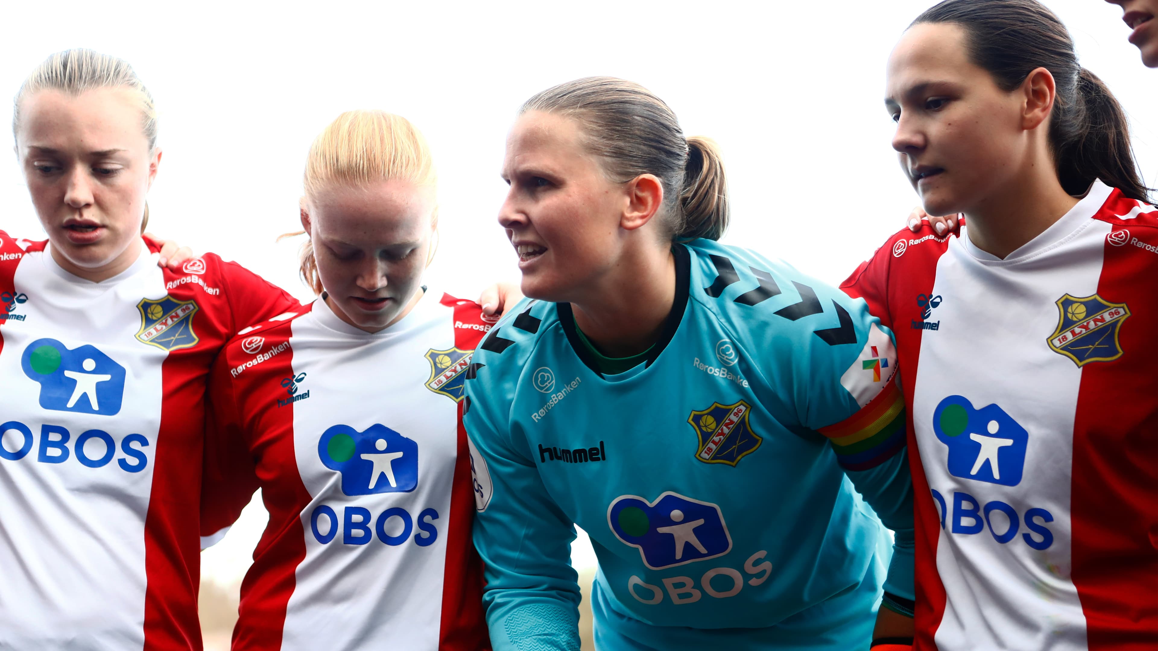 Foto av fire spillere for Lyn Damer som har en gruppesamtale.