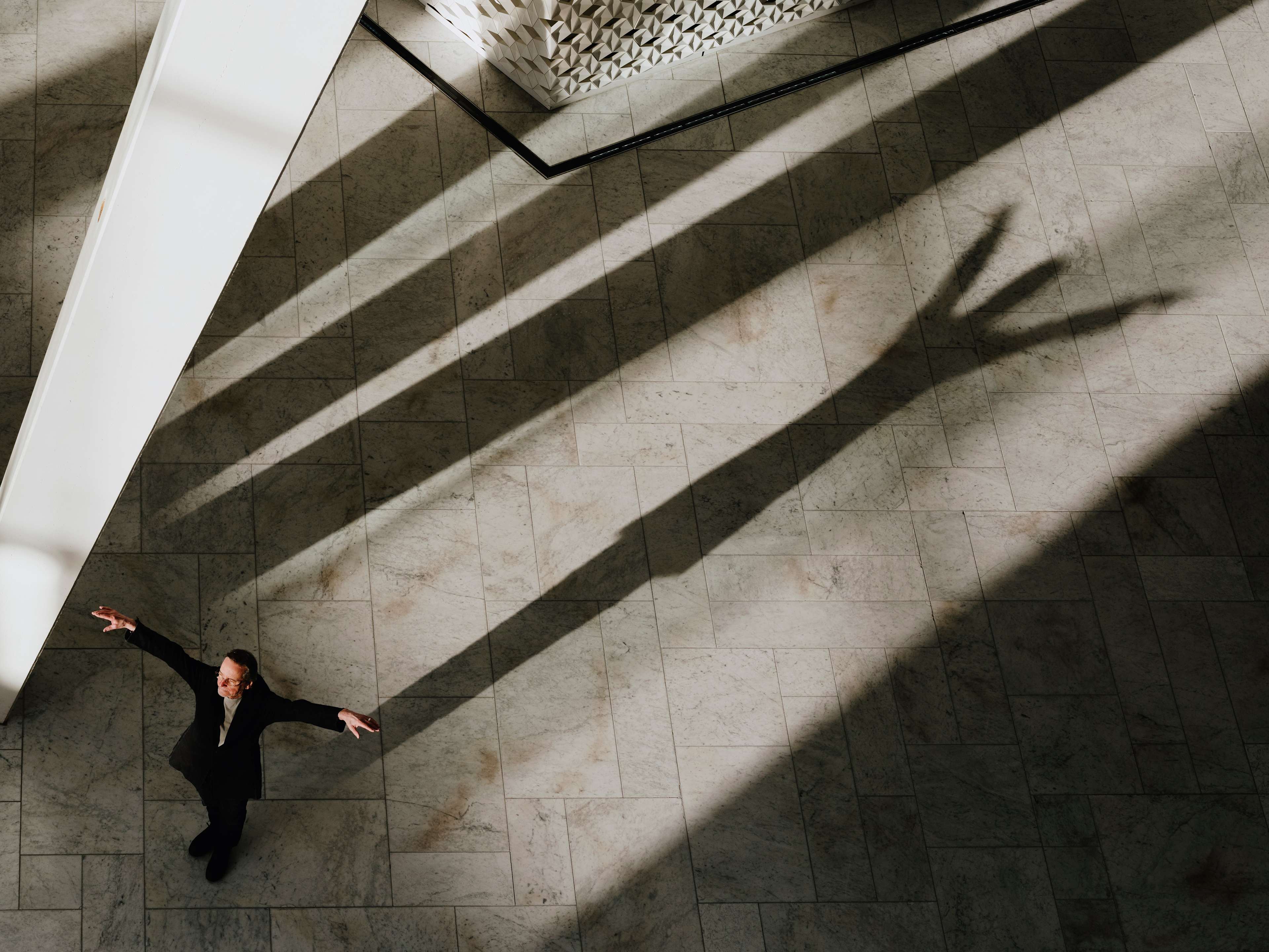 Foto av Kylian ved Den Norske Opera & Ballett som lager skyggekunst ved inngangen.