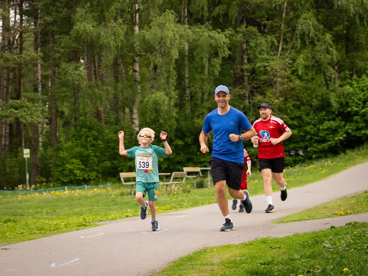 Foto av en ung gutt og en mann som smiler mens de løper Nordstrandsløpet sammen.