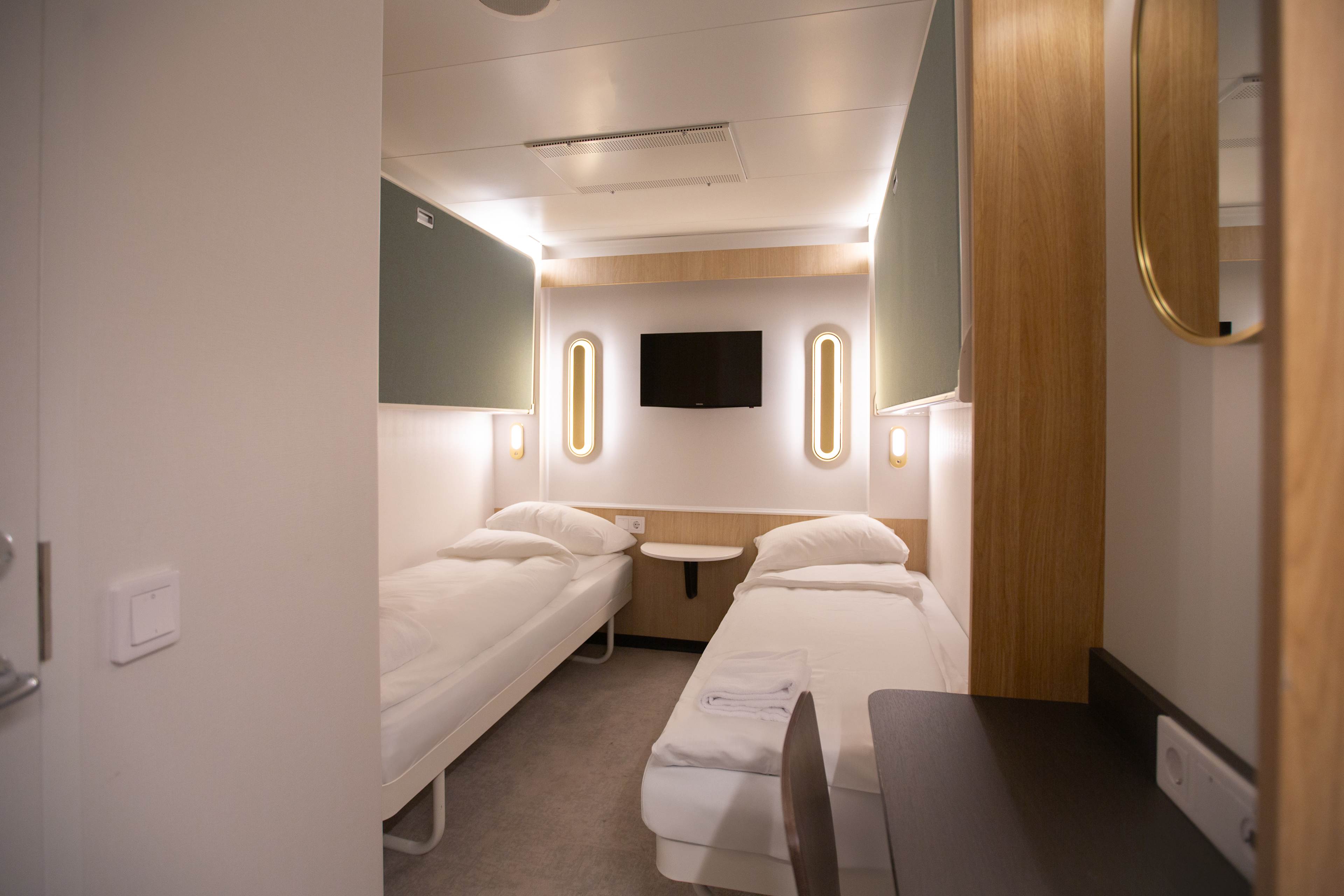 Nye standard lugarer Go Nordic Cruiseline. To senger på hver sin side av rommet. Grønt på veggene.