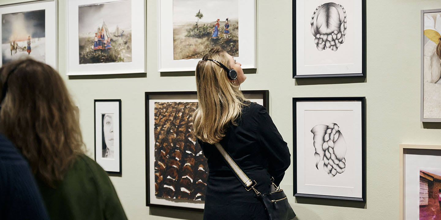 Medlem som kollar på konstverk som hänger på väggen