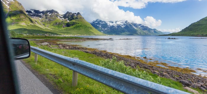 Fjord og fjellandskap, tatt fra innsiden av en bil