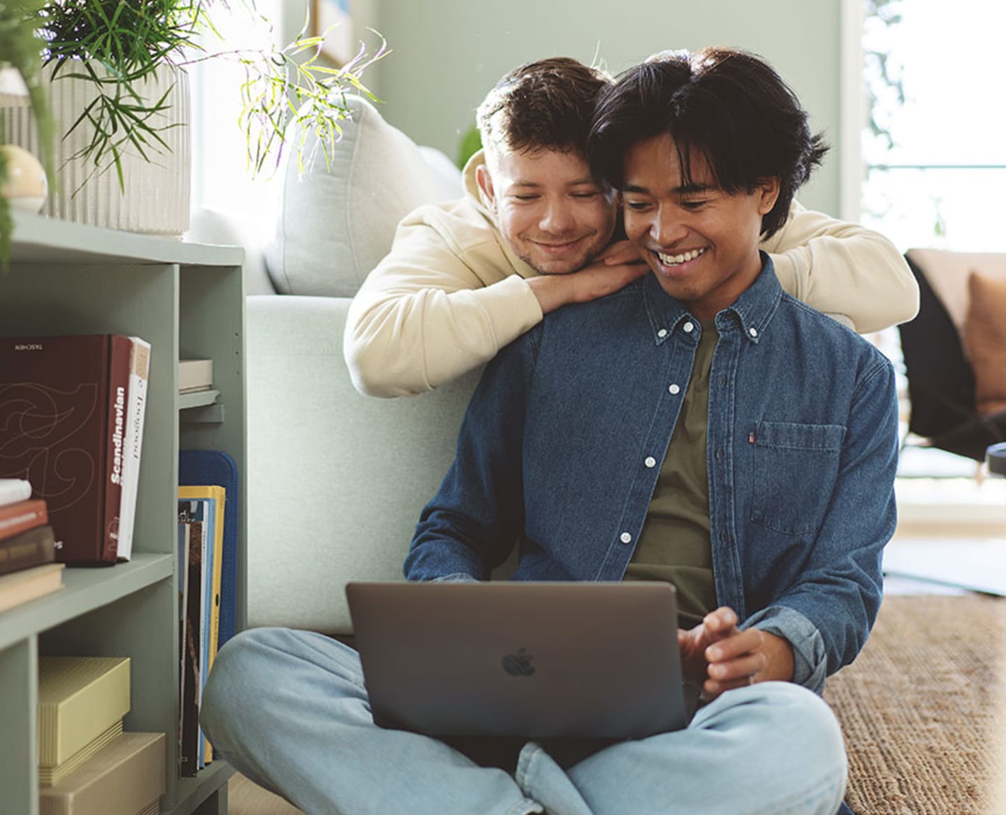 Ungt par ser på laptopskjerm og smiler