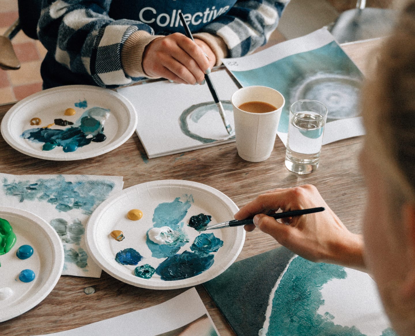 To mennesker som maler sosialt kunstverk sammen med Art Collective-jentene Nora Kielland og Julie Solberg