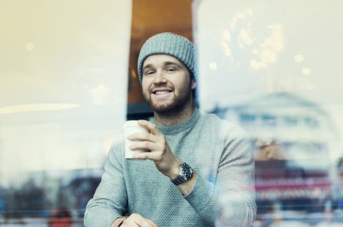 Bilde av en mann som sitter på kafé og drikker kaffe