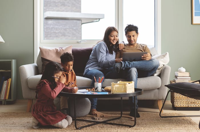 En familie med to barn og foreldre i en sofa