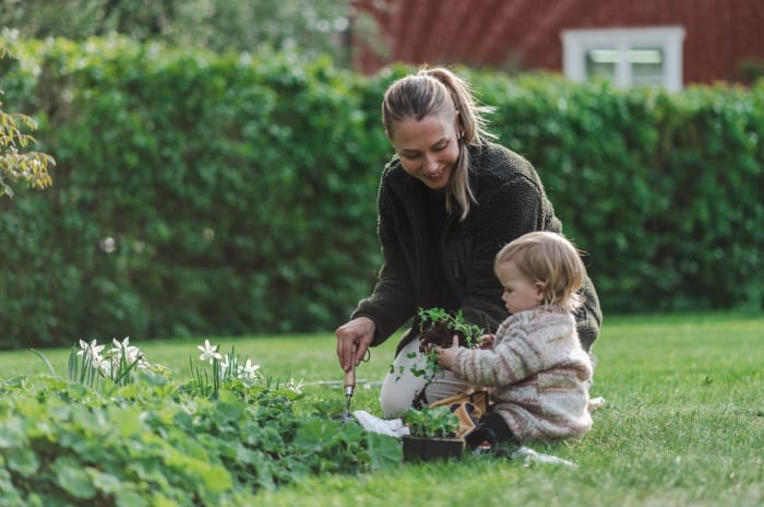 Kvinna med barn i trädgård