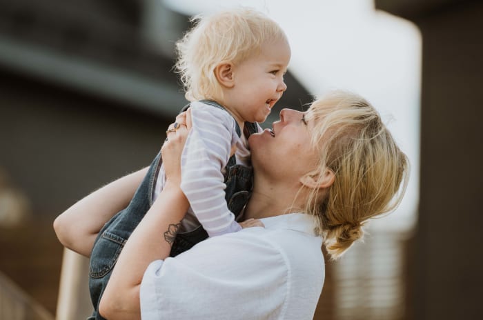 mamma lyfter sitt barn