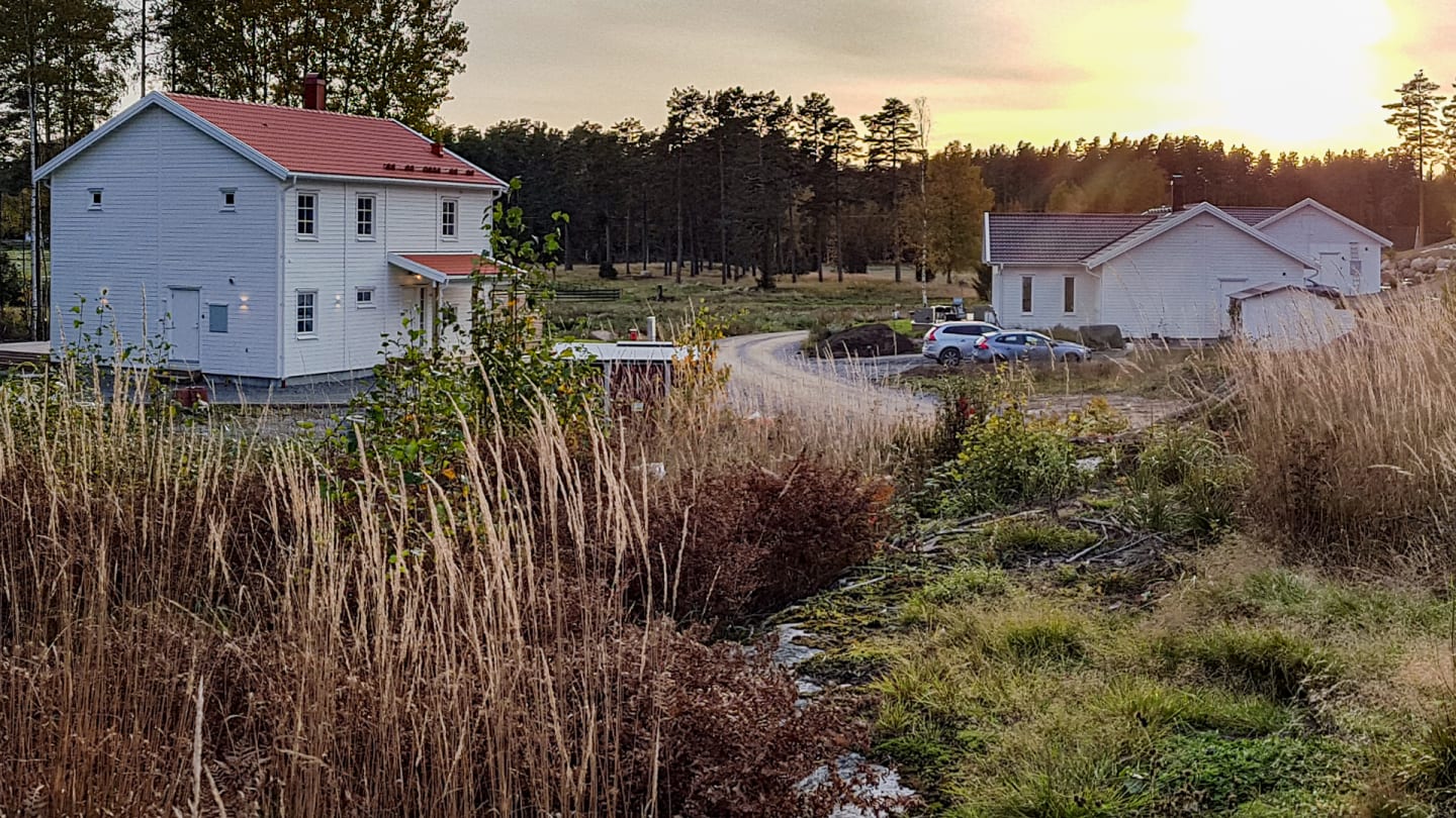 två vita hus i ett naturskönt område