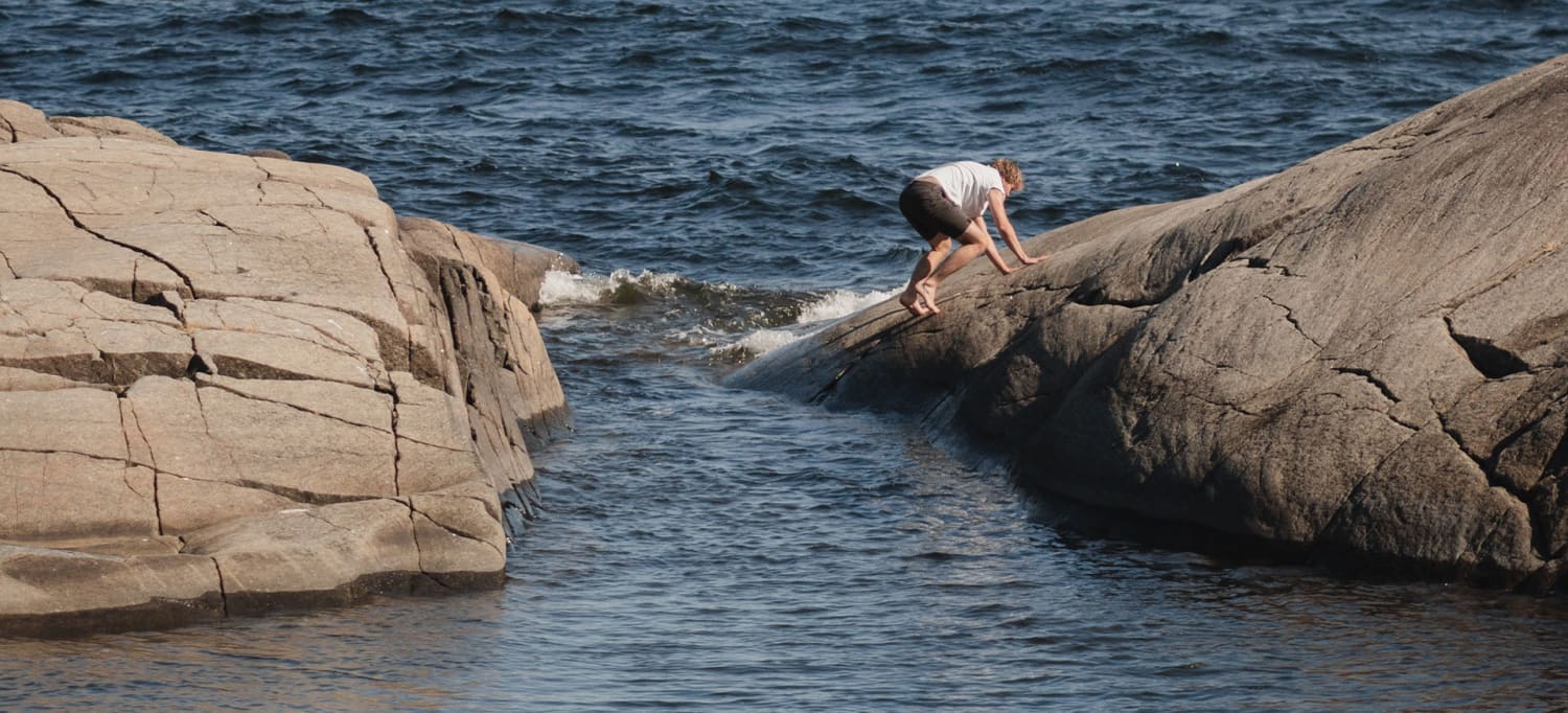 kille som klättrar på klippor