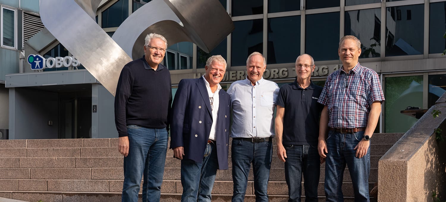 Fem menn fra driftsavdelingen hos OBOS Eiendom står foran statuen på Hammersborg Torg.