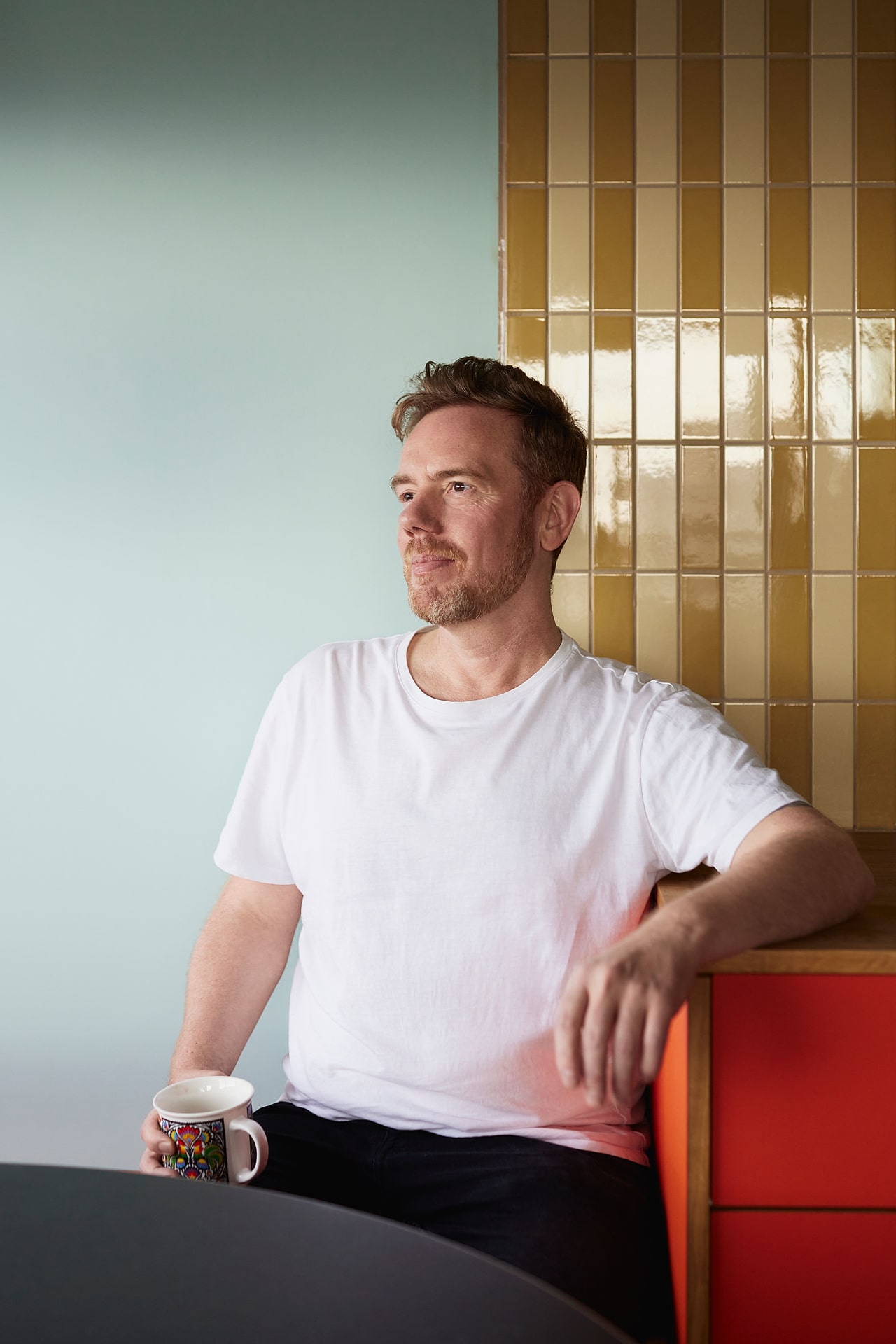 Bilde av Lars som sitter ved spisebordet med en kaffekopp i hånda.
