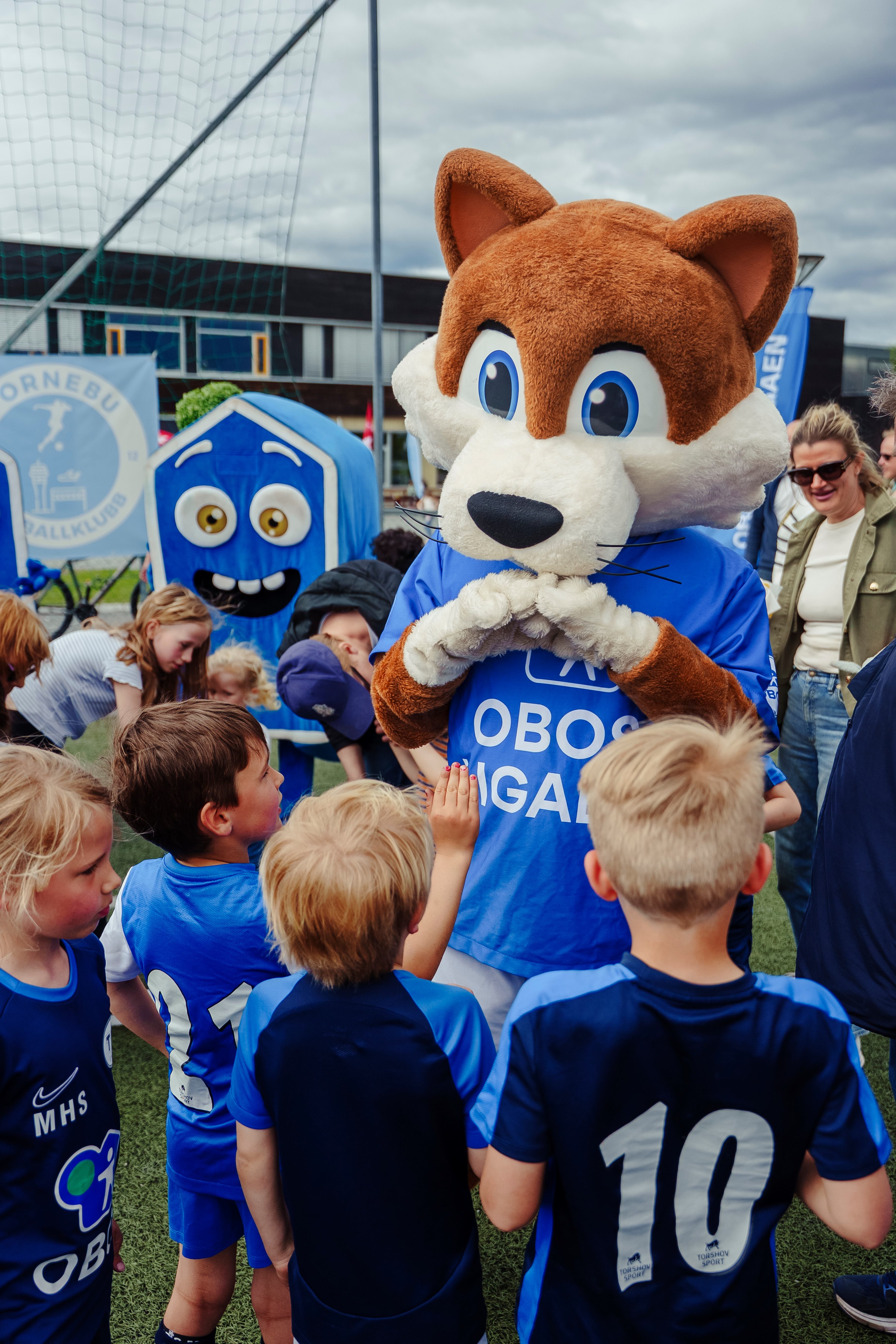 Foto av barna som står ved OBOS-maskoten.