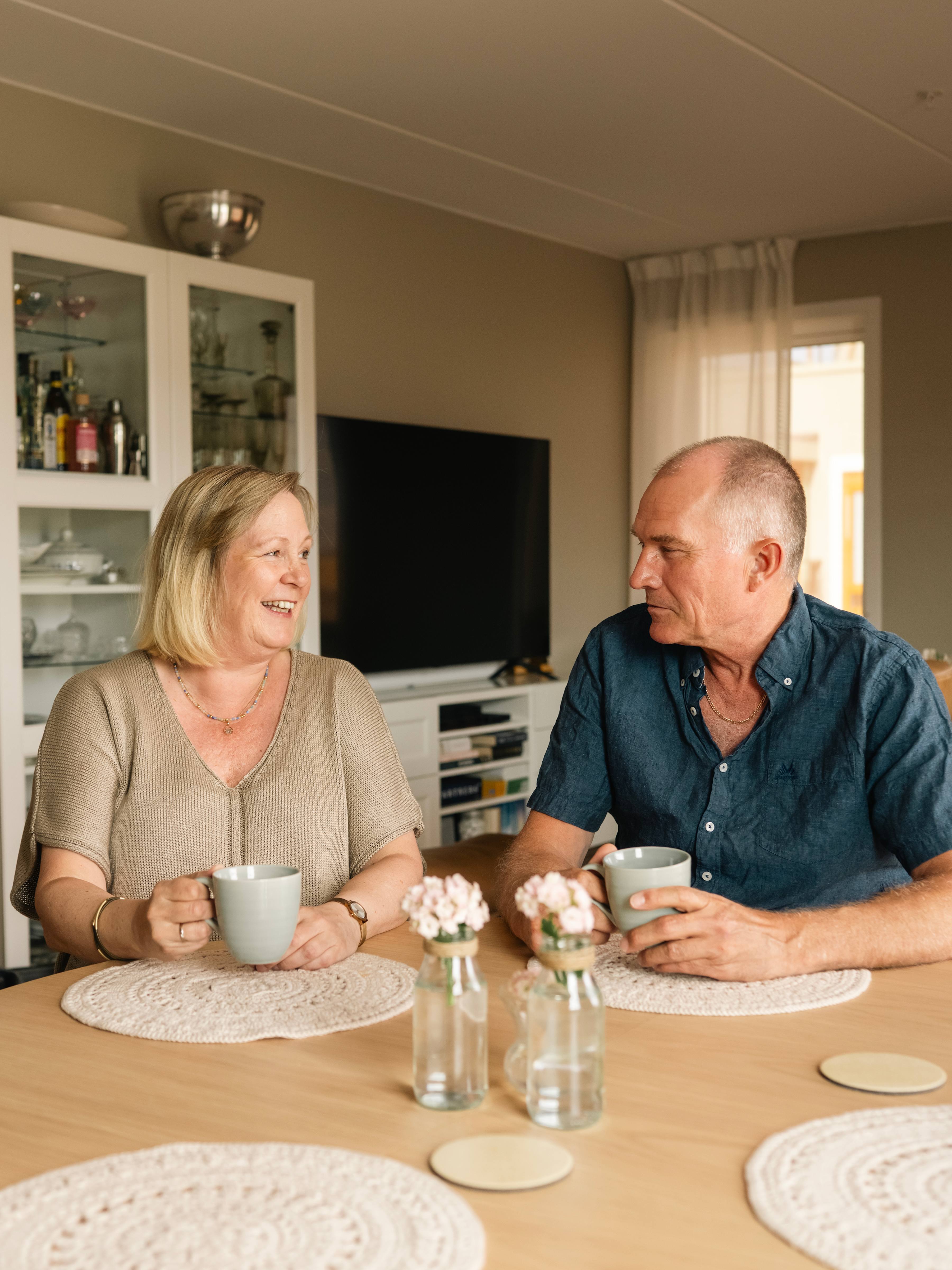 Foto av Helene og Morten med hver sin kaffekopp i hånda, sittende ved spisebordet i sin nye leilighet på Kvarteret i Lillestrøm