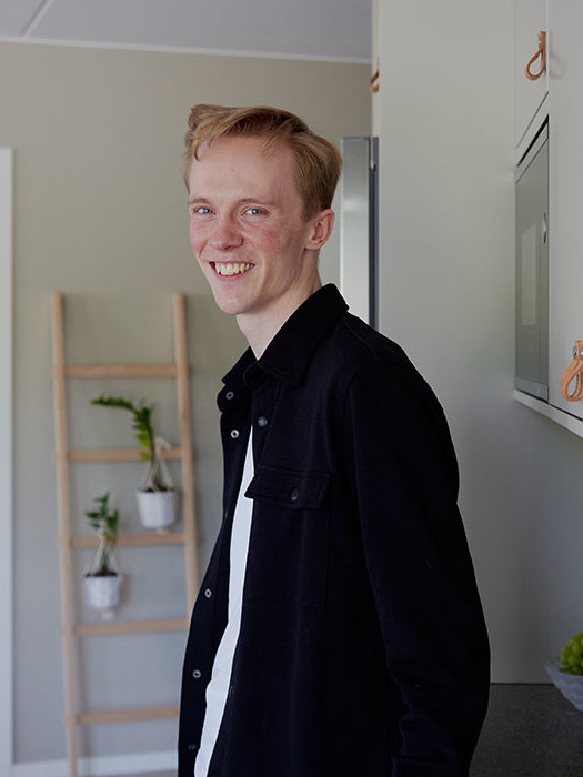 Axel lutar sig mot diskbänken i köket