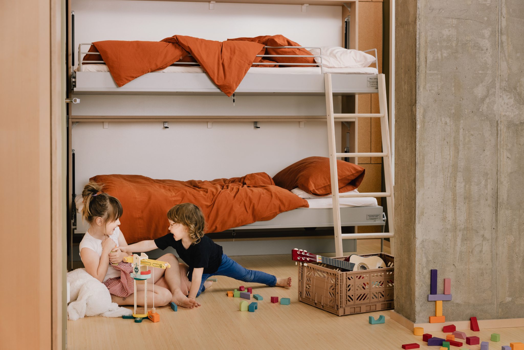 Foto av to barn som leker på gulvet på et barnerom i OBOS Living Lab