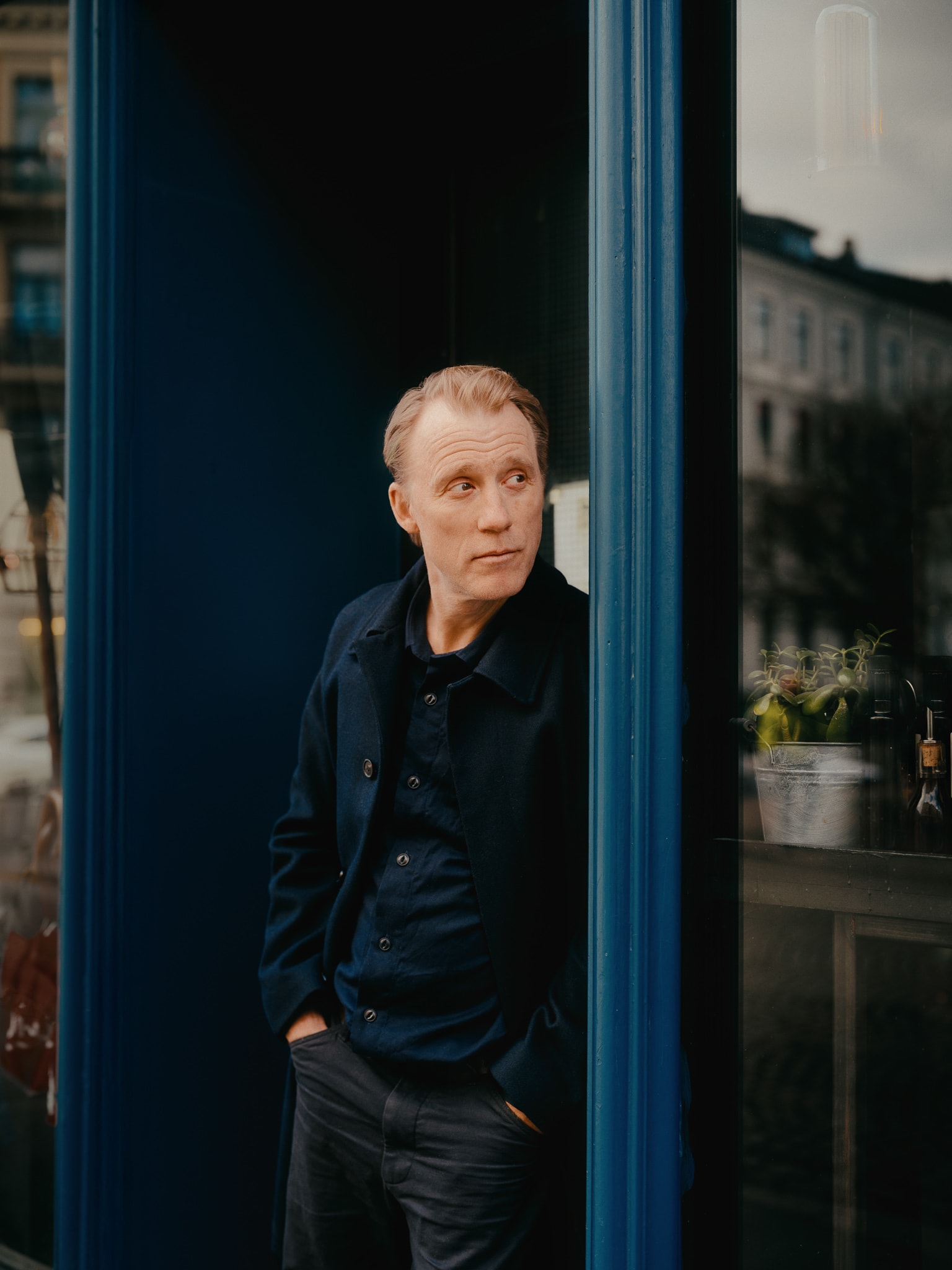 Thorbjørn Harr står lent inntil en dørkarm.