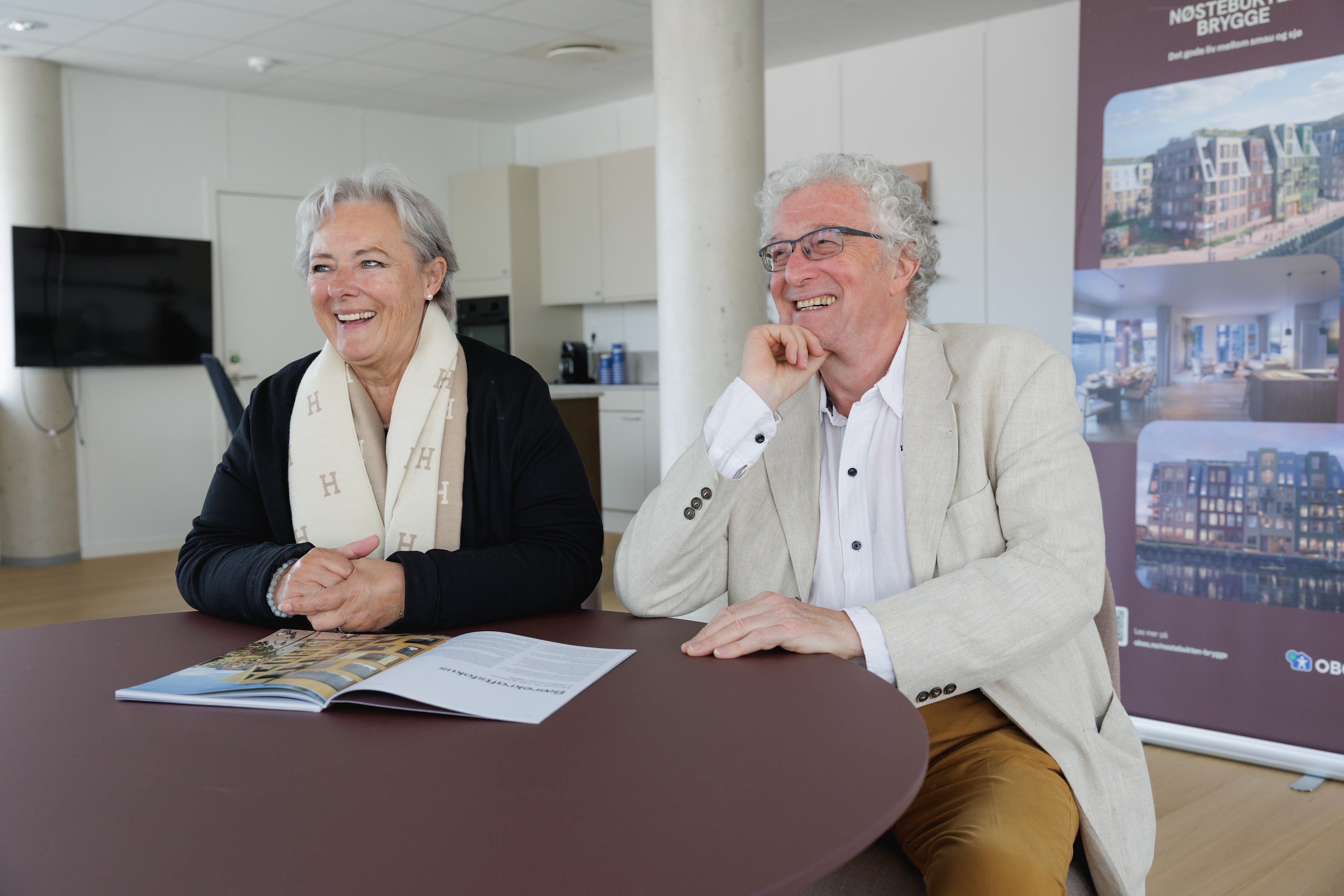 Edna og Øyvind sitter og smiler ved et bord