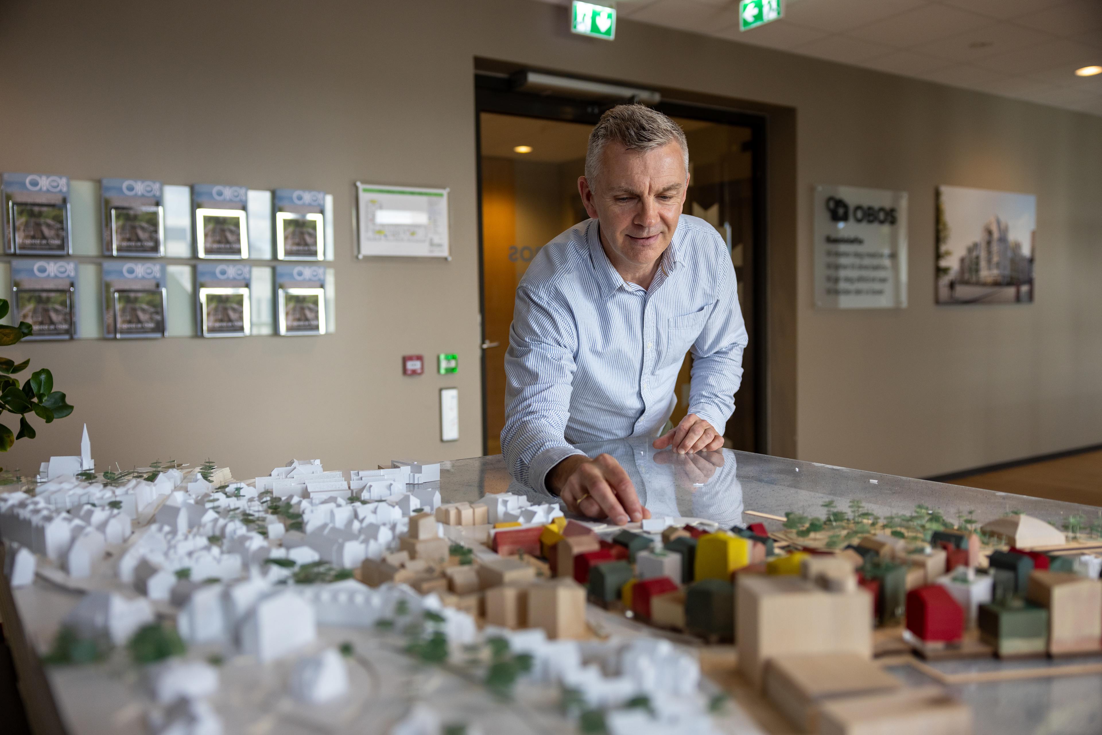 Øyvind står og jobber med en modell av Bergen