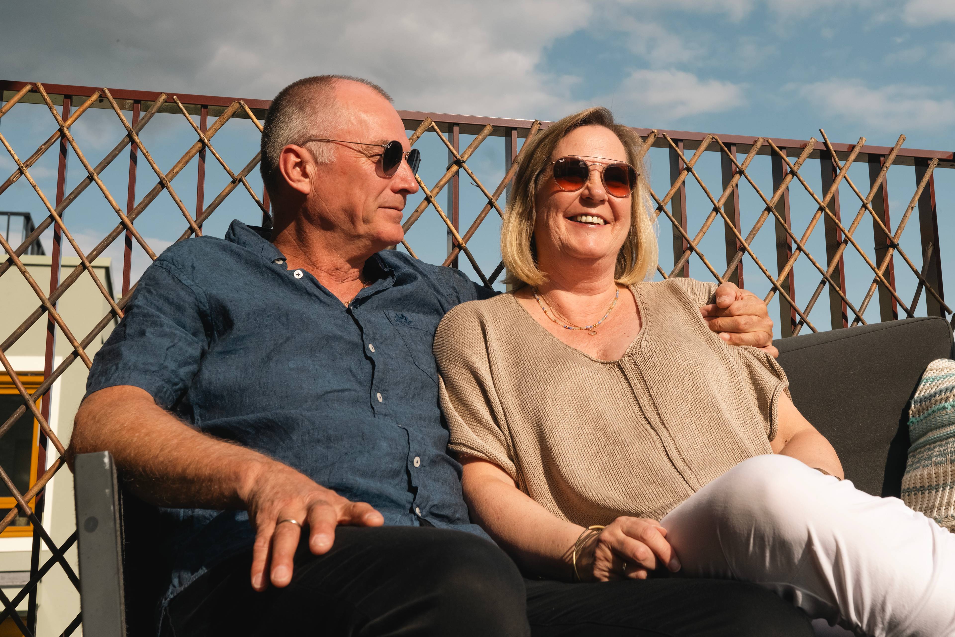 Foto av Helene og Morten som sitter og nyter sola på balkongen i leiligheten i Kvarteret, Lillestrøm