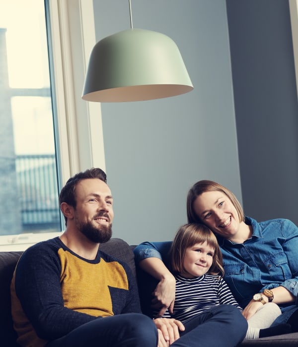 Familie sitter sammen i sofaen og ser samlet på noe