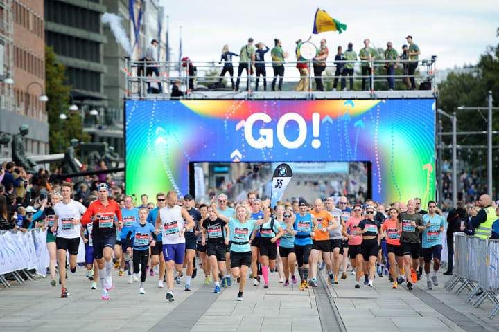 Bilde fra Oslo Maraton med en mengde mennesker som løper ut av startsstreken.