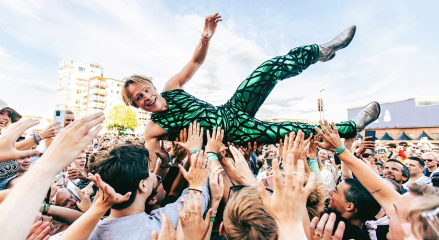 Foto av artisten Sondre Justad som crowd-surfer på en konsert.