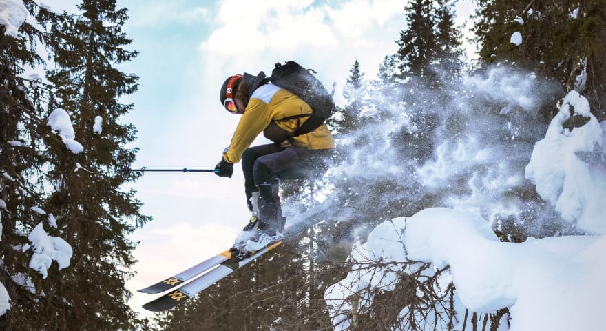 Vinterbilde av en mann som kjører slalom i skogen.