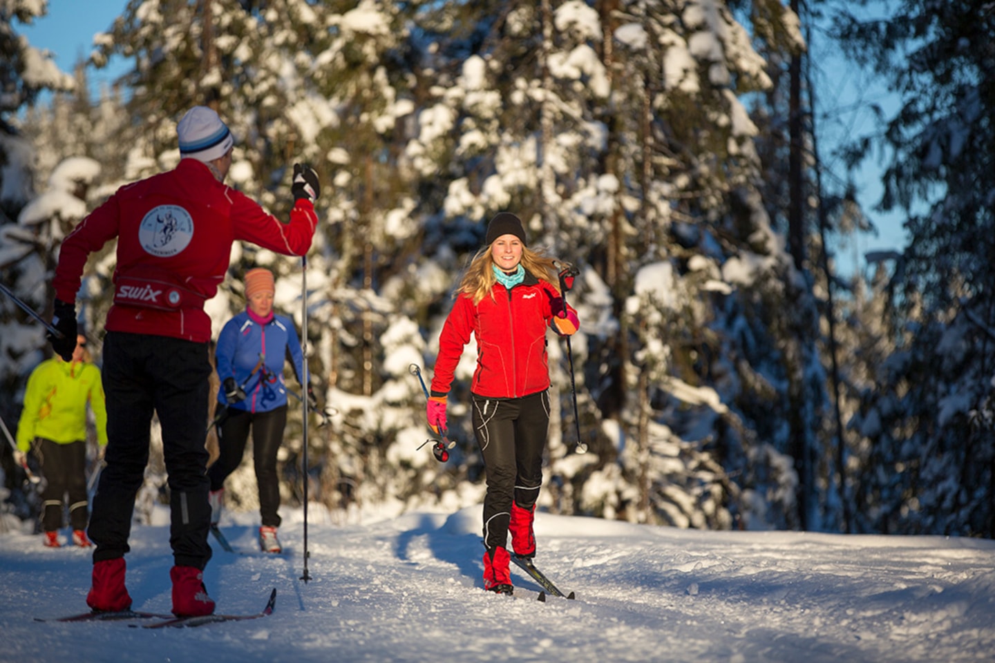Skiinstruktør går bortover i fine forhold.