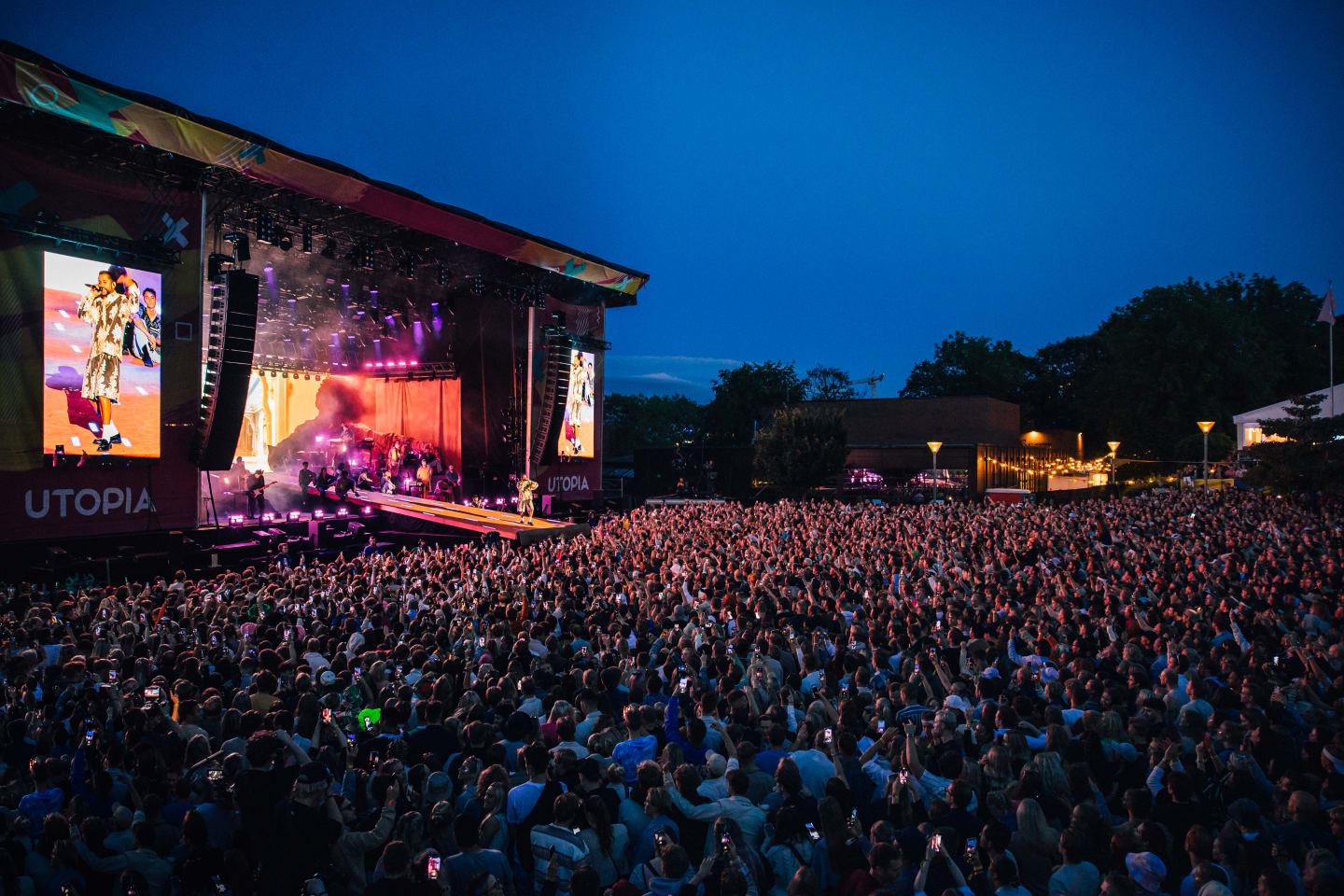 Scenebilde fra publikumshavet som ser mot konsertscenen en sommerkveld.