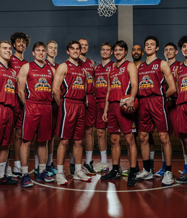 Et oppstilt basketball-lag med menn som smiler