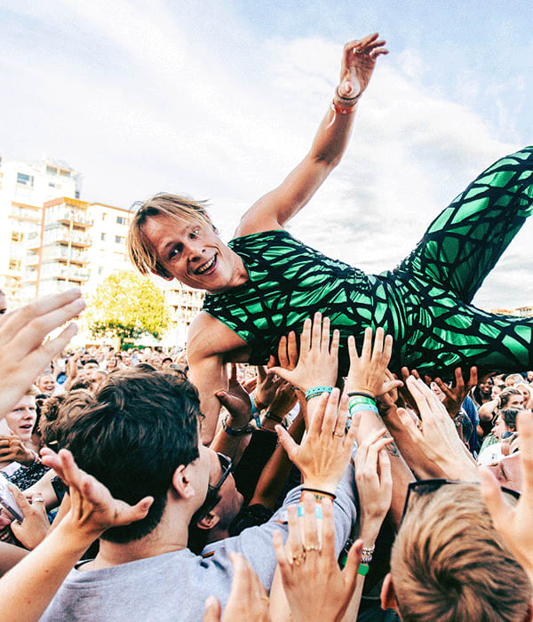 Foto av artisten Sondre Justad som crowd-surfer på en konsert.