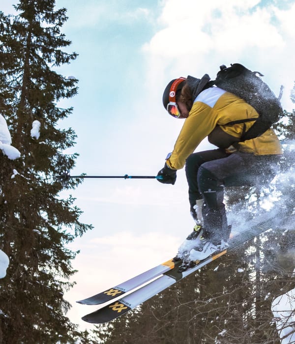Vinterbilde av en mann som kjører slalom i skogen.