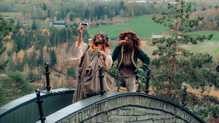 Bilde av en familie som tar en vannattraksjon på Hunderfossen med Trollet i bakgrunnen.