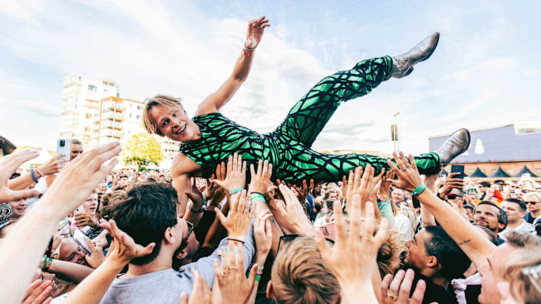 Foto av artisten Sondre Justad som crowd-surfer på en konsert.