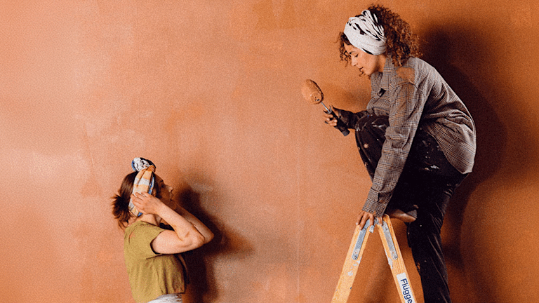 Två kvinnor som målar om