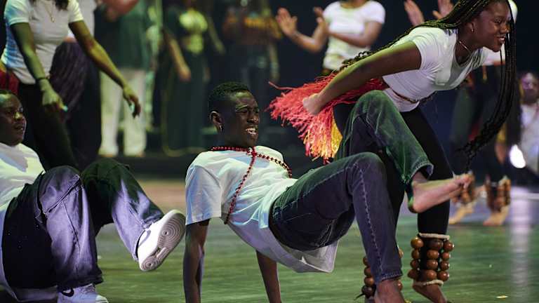 Foto av tre deltakere som danser på scenen på en av forestillingene.