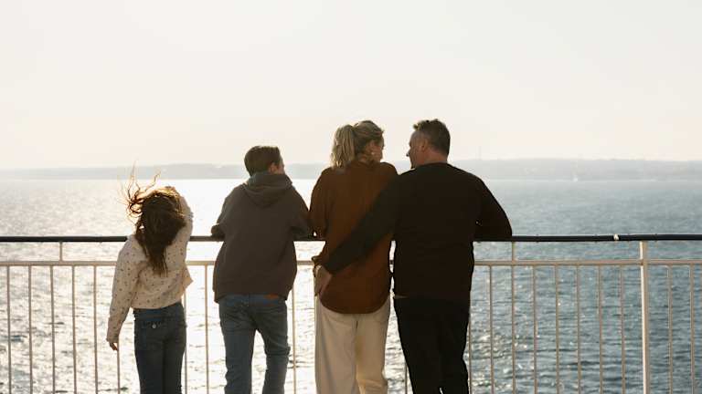 Medlemsside til dfds cruise til danmark. Båt kjører på stille vann med fine værforhold og skog i bakkant.