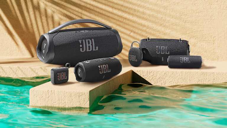Flere ulike JBL høyttalere står oppstilt ved et vann.