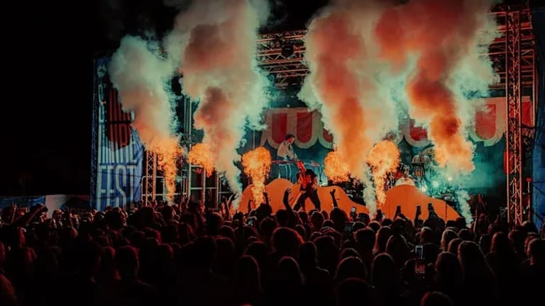 Publikumshav foran scenen på Spirefest. Det kommer flammer og røyk fra scenen.